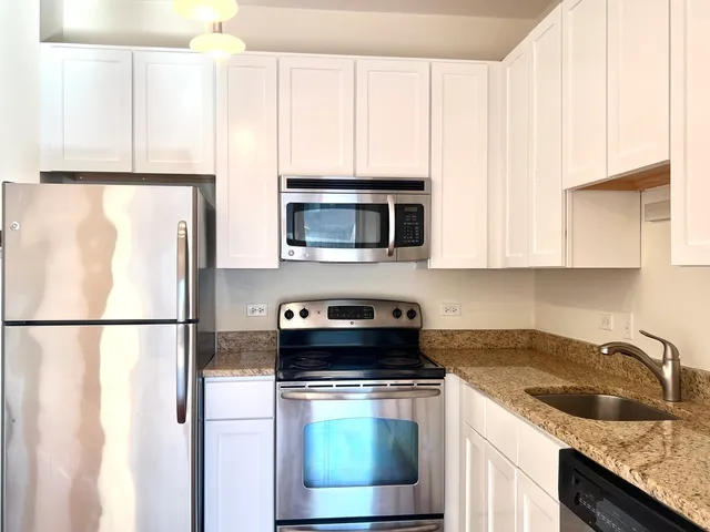 a kitchen with appliances a microwave and cabinets