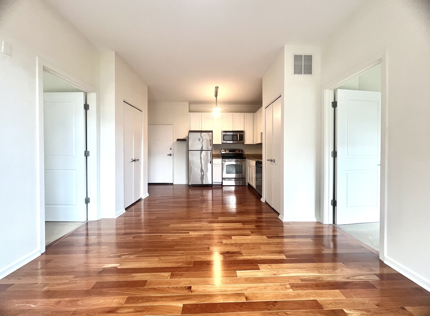 1 East 8th Street, Unit 307 Chicago, IL 60605 - Photo 9 of 23 a view of a kitchen with kitchen island an empty room and wooden floor