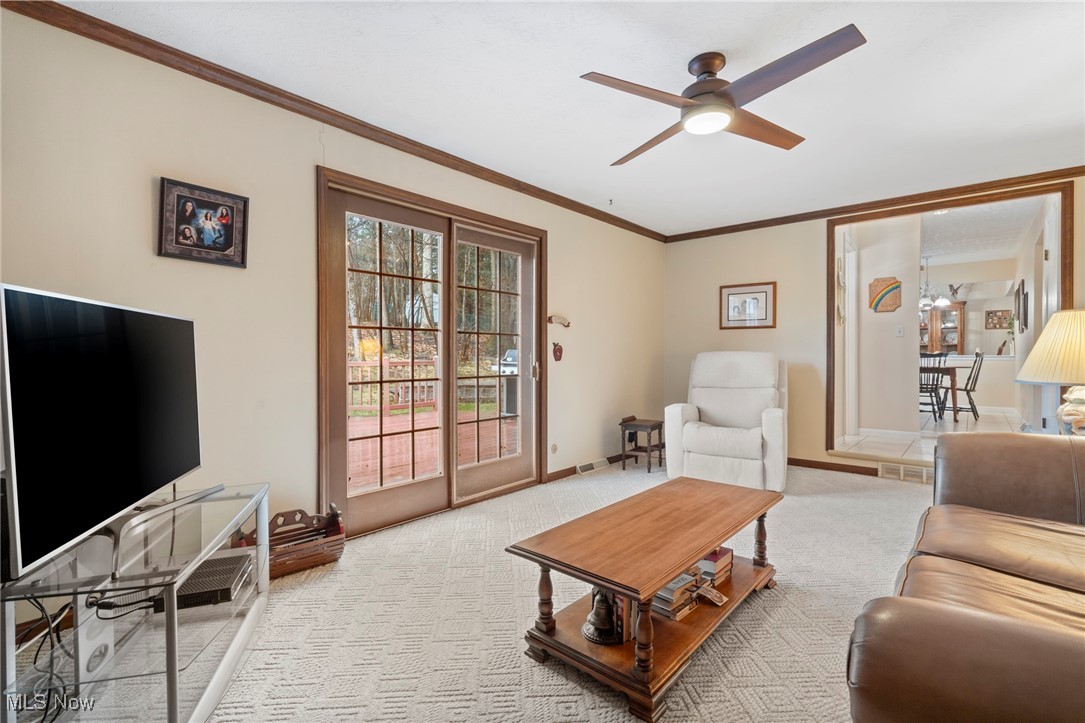 7353 Ames Road Cleveland, OH 44129 - Photo 23 of 45 Living room featuring crown molding, baseboards, visible vents, a ceiling fan, and light carpet