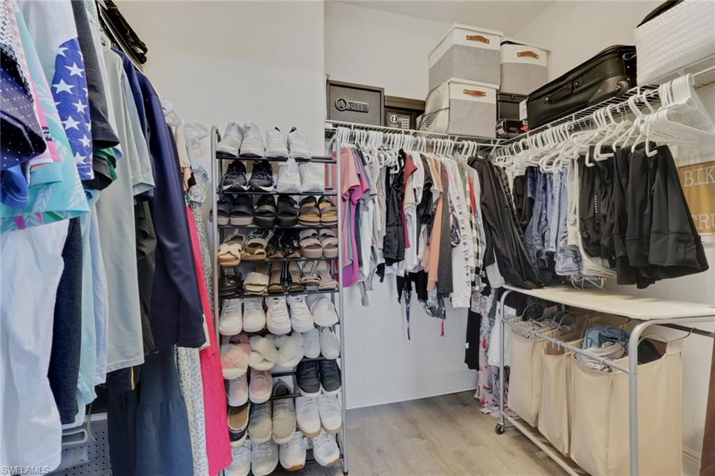 15464 Cortona Way Naples, FL 34120 - Photo 19 of 47 a view of walk in closet with clothes and shoes