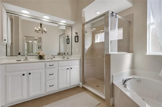 a bathroom with a tub a sink shower and mirror