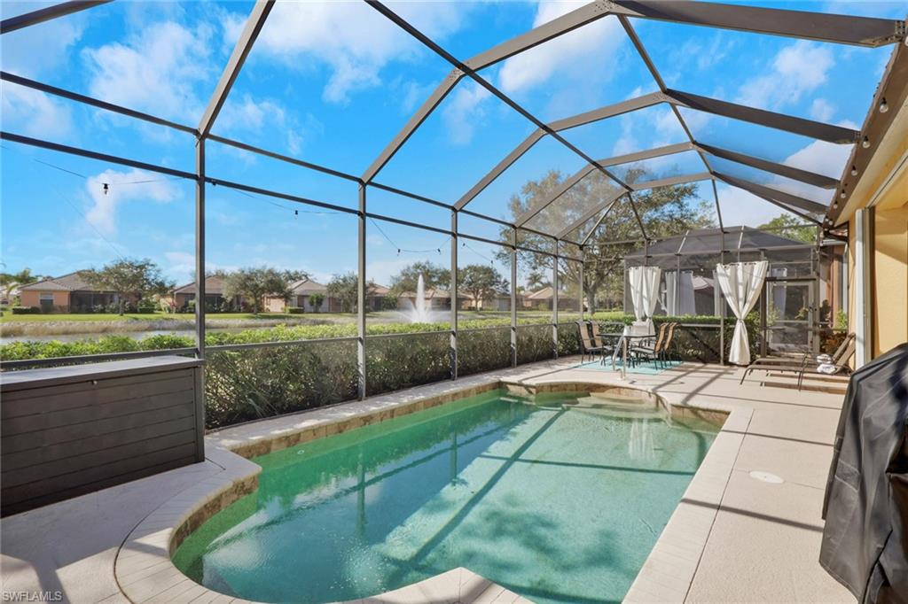 15464 Cortona Way Naples, FL 34120 - Photo 2 of 47 Outdoor pool featuring a lanai, a sunroom, a patio, and a residential view