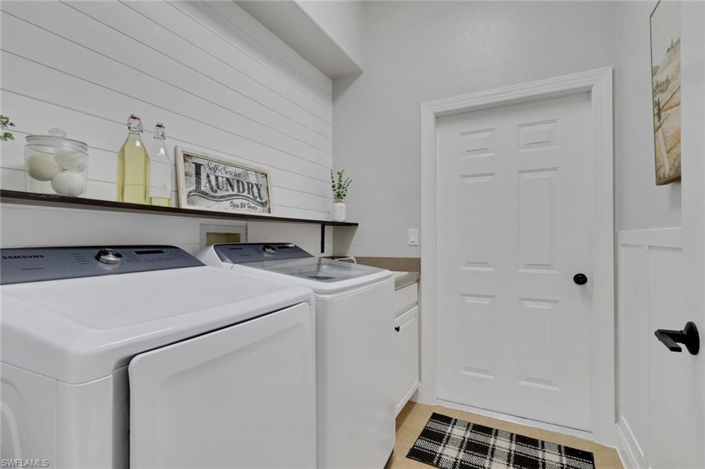 15464 Cortona Way Naples, FL 34120 - Photo 26 of 47 Laundry area featuring washer and dryer and cabinet space