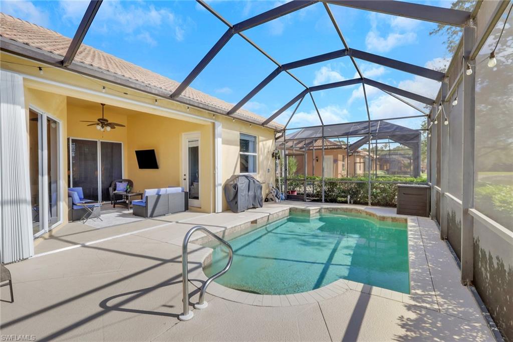 15464 Cortona Way Naples, FL 34120 - Photo 28 of 47 Swimming pool featuring a sunroom, a lanai, a patio area, area for grilling, and an outdoor living space