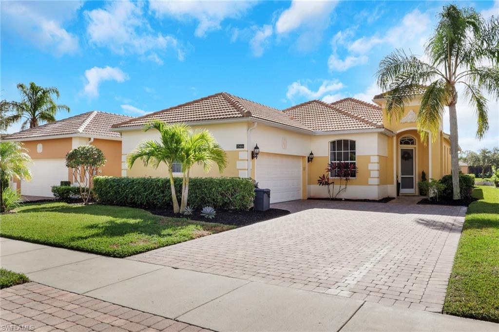 15464 Cortona Way Naples, FL 34120 - Photo 3 of 47 Mediterranean / spanish house featuring a front yard, stucco siding, a garage, and decorative driveway
