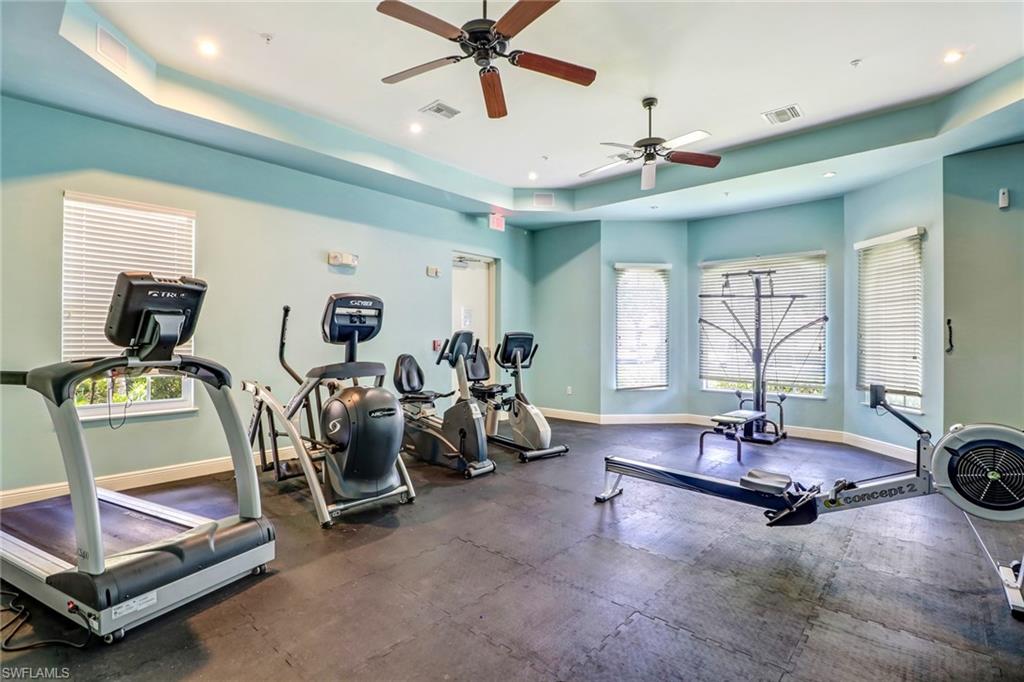 15464 Cortona Way Naples, FL 34120 - Photo 33 of 47 a room with gym equipment and windows