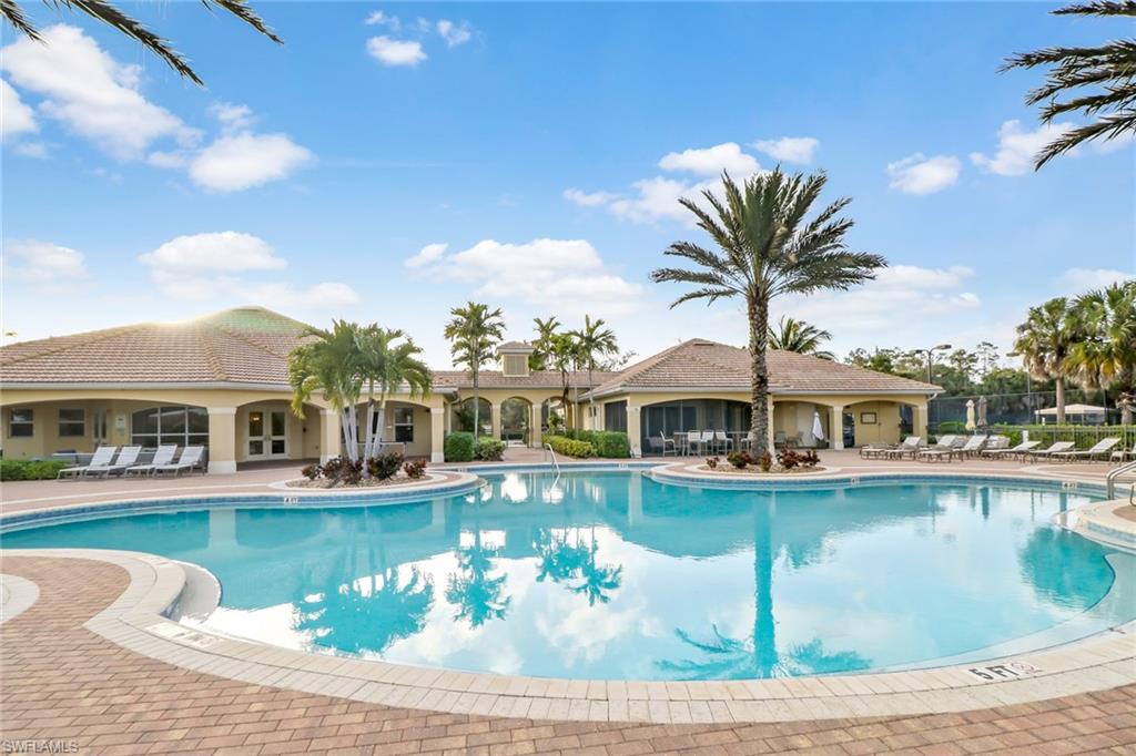 15464 Cortona Way Naples, FL 34120 - Photo 34 of 47 a front view of a house with yard swimming pool and outdoor seating