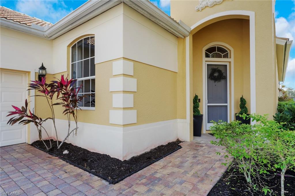 15464 Cortona Way Naples, FL 34120 - Photo 4 of 47 Entrance to property featuring stucco siding, a garage, and a tiled roof