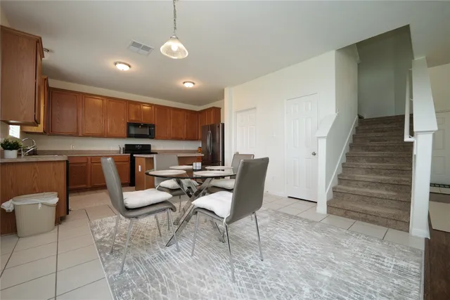 a kitchen with a table chairs refrigerator and cabinets