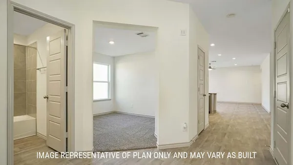a view of a hallway with wooden floor and a bathroom