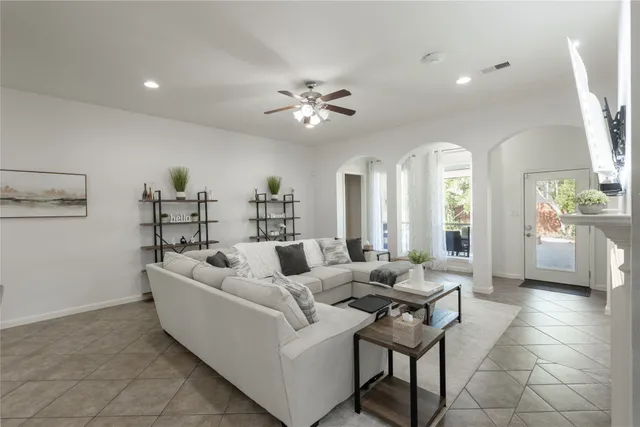 a kitchen with stainless steel appliances kitchen island granite countertop a refrigerator a stove a kitchen island a couches and a dining table with wooden floor