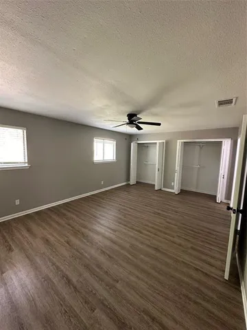 a view of empty room with wooden floor and window
