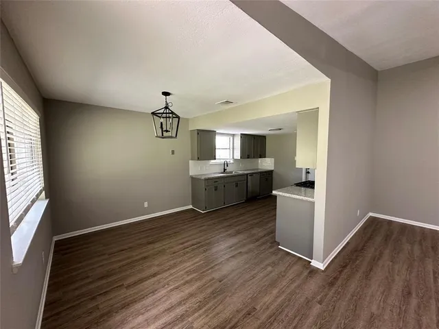 a view of a kitchen with wooden floor and electronic appliances