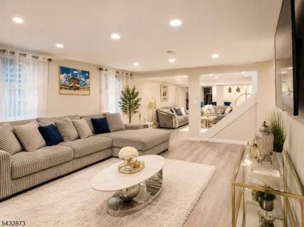 a living room with furniture and a dining table with wooden floor