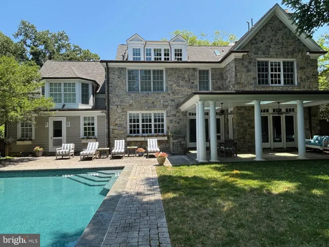 a front view of a house with swimming pool and sitting area