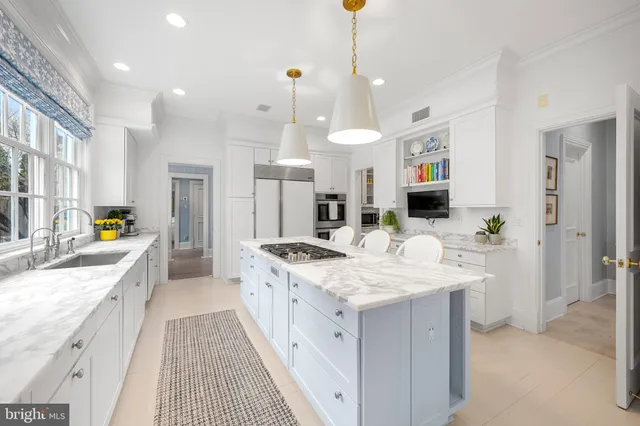 a large white kitchen with a stove a sink a refrigerator and a refrigerator