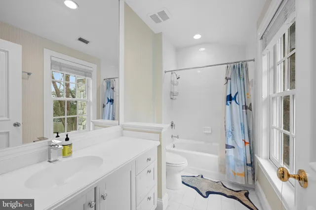 a bathroom with a granite countertop toilet a sink and a mirror