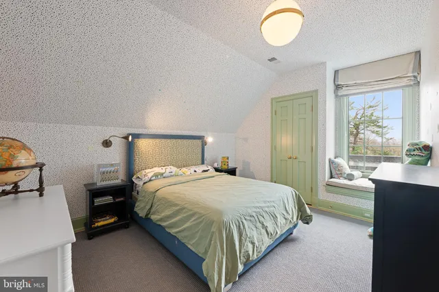 a spacious bedroom with a bed and a window