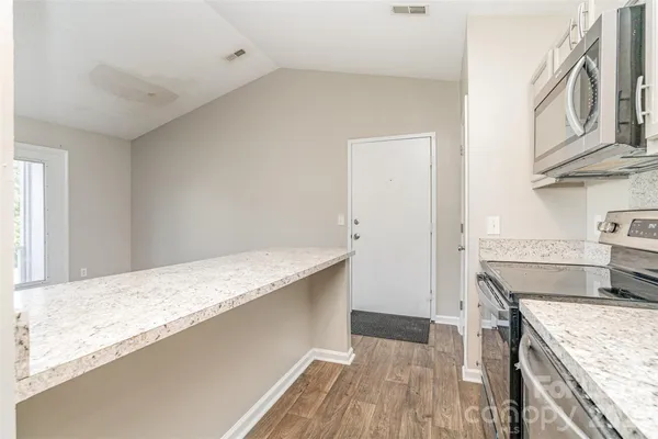 a kitchen with granite countertop a sink and a stove