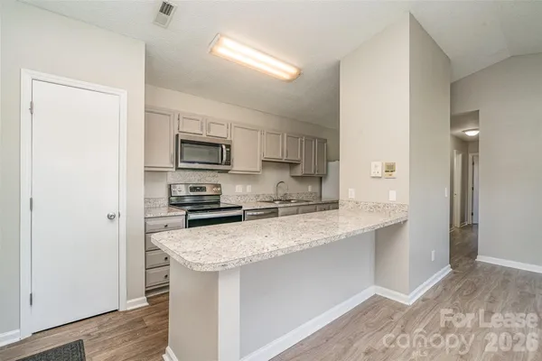 a kitchen with a sink a microwave a refrigerator and cabinets