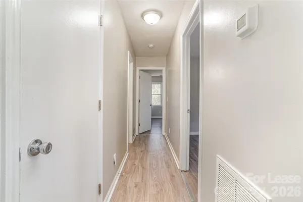 a view of a hallway with wooden floor