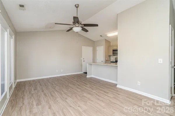 a view of an empty room and window and wooden floor