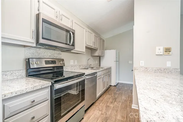 a kitchen with stainless steel appliances granite countertop a stove microwave and sink