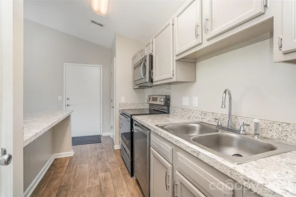 a kitchen with stainless steel appliances granite countertop a sink stove and refrigerator