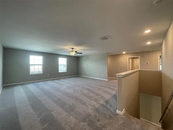 a view of empty room with window and wooden floor