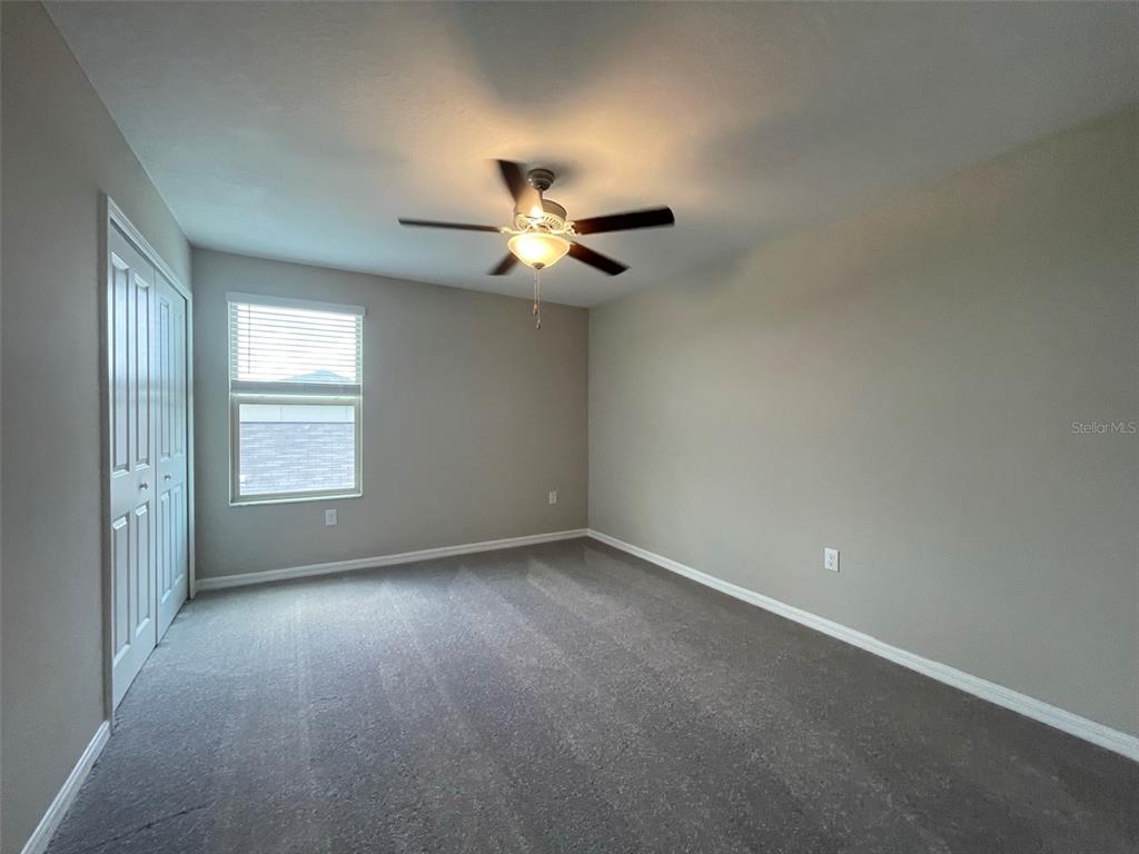 31796 Sun Kettle Loop Wesley Chapel, FL 33545 - Photo 18 of 21 an empty room with a window and a ceiling fan