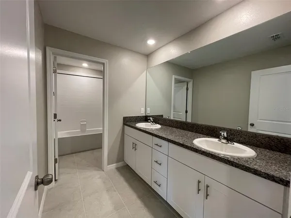 a bathroom with double sink and a mirror