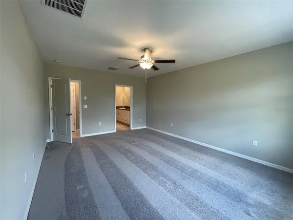 a view of an empty room and a ceiling fan window