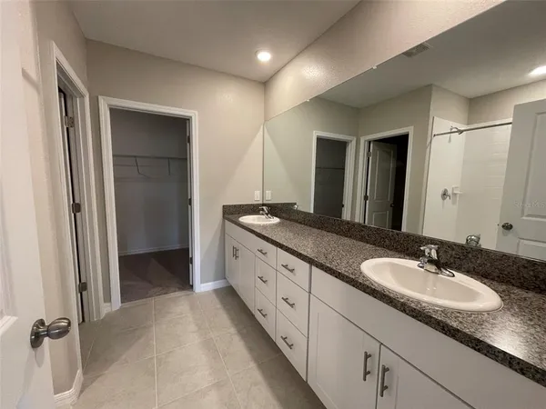 a spacious bathroom with a granite countertop sink and a mirror