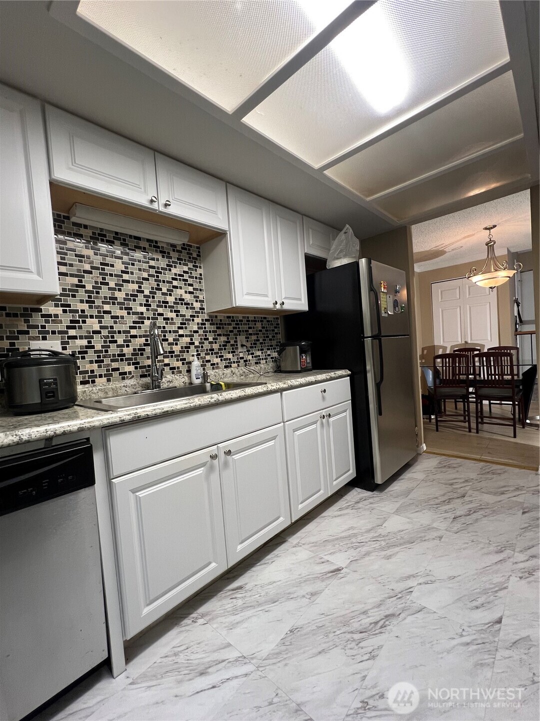 17526 151st Avenue Southeast, Unit 41 Renton, WA 98058 - Photo 3 of 16 a kitchen with stainless steel appliances kitchen island granite countertop a refrigerator and a stove top oven