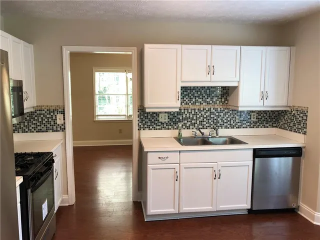 a kitchen with a sink stove and cabinets