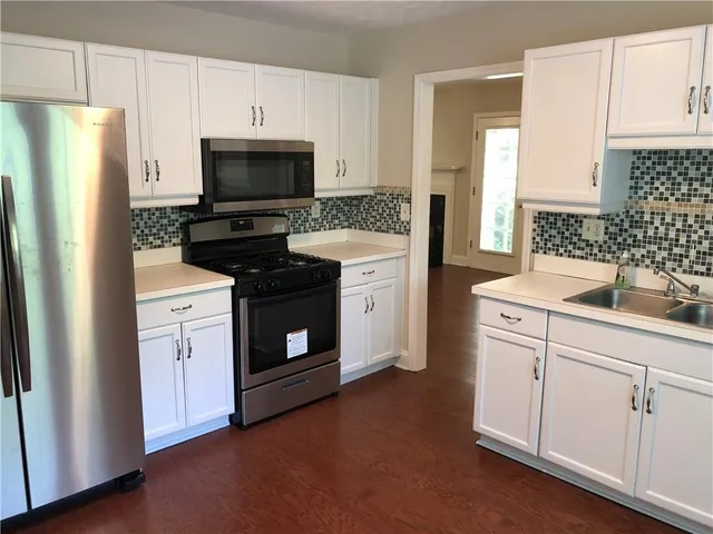 a kitchen with white cabinets and stainless steel appliances