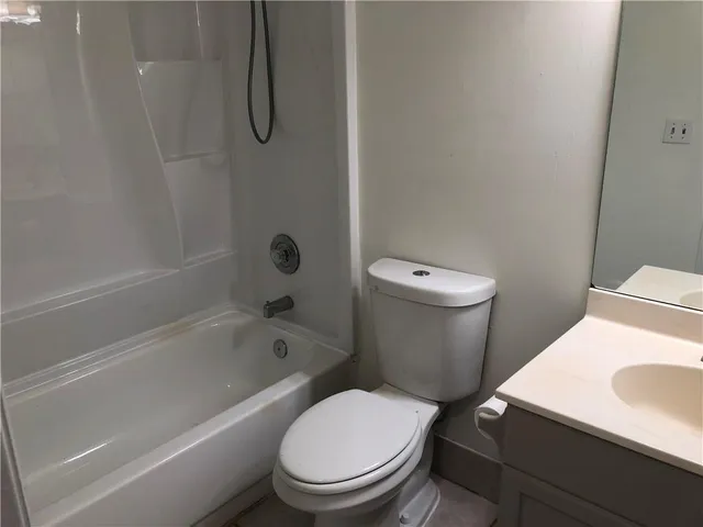 a white toilet sitting next to a bath tub and a shower