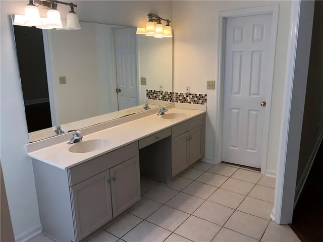 a bathroom with a double vanity sink mirror and