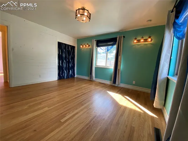 a view of an empty room with wooden floor
