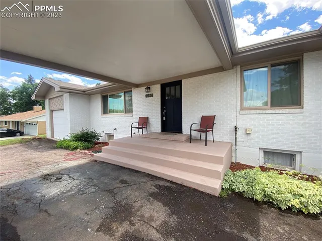 a view of a porch with chairs and potted plants