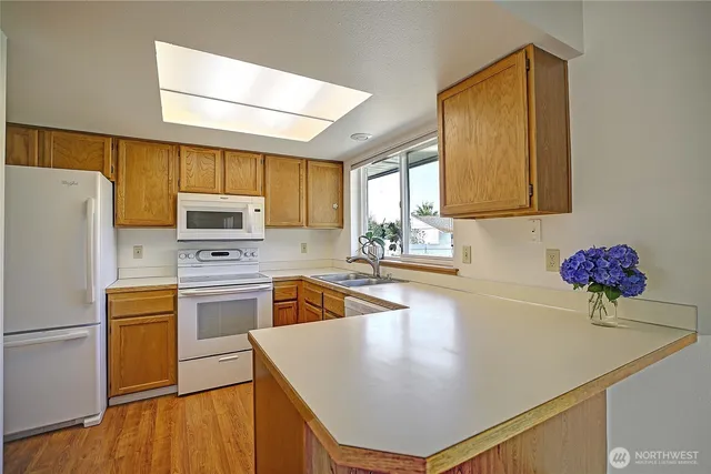a kitchen with stainless steel appliances a refrigerator sink stove microwave and cabinets