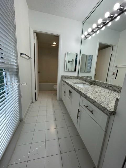 9721 East Bay Harbor Drive, Unit 3C Bay Harbor Islands, FL 33154 - Photo 10 of 17 a bathroom with a granite countertop sink a toilet and a mirror