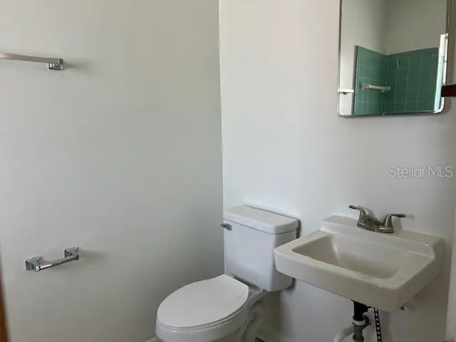 a white toilet sitting next to a white sink