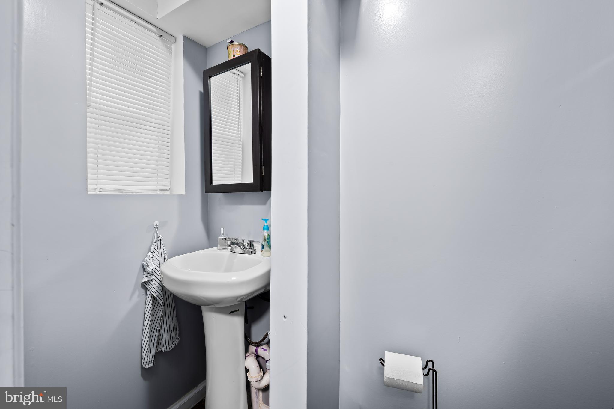 236 South Gilmor Street Baltimore, MD 21223 - Photo 11 of 28 a bathroom with a sink a mirror and a window