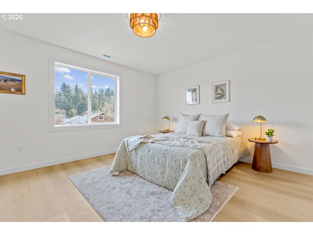 401 South 1st Street Silverton, OR 97381 - Photo 7 of 12 a spacious bedroom with a bed and wooden floor