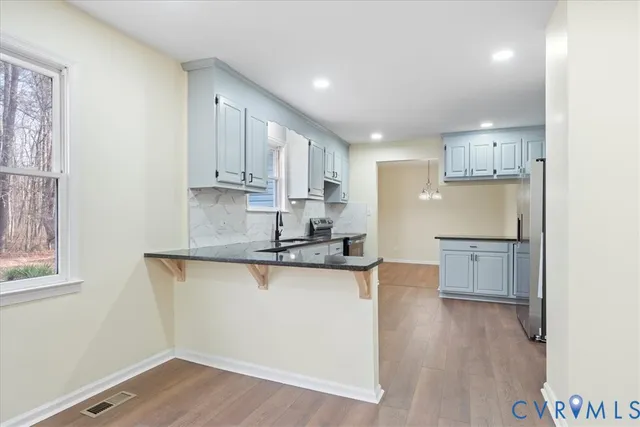 a kitchen with white cabinets and refrigerator