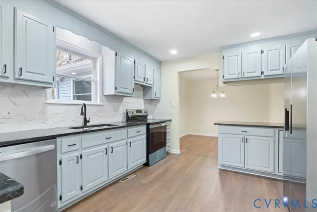 a kitchen with stainless steel appliances granite countertop a refrigerator and a sink