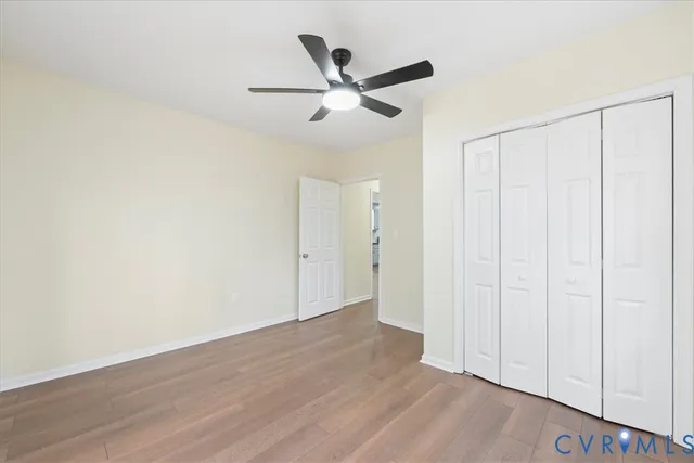 a view of a house with a large tree and wooden fence