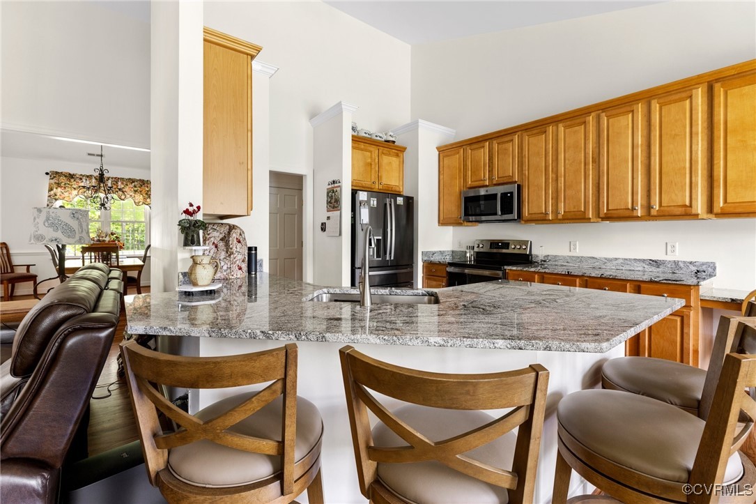 1629 Olmstead Drive Powhatan, VA 23139 - Photo 14 of 50 a kitchen with stainless steel appliances granite countertop a stove top oven a sink a dining table and chairs