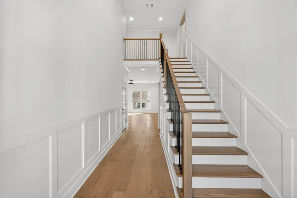 a view of a hallway with wooden floor and staircase